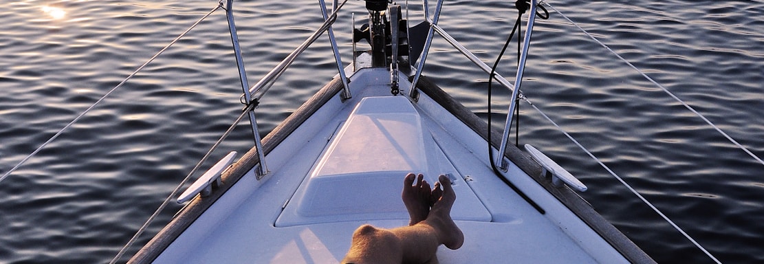 man lying on white boat